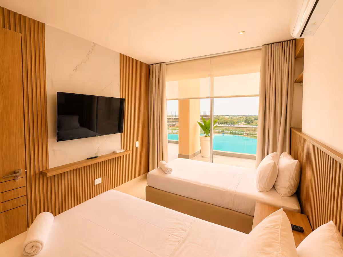 Habitación con muro de listones detrás del TV y vista a la laguna
