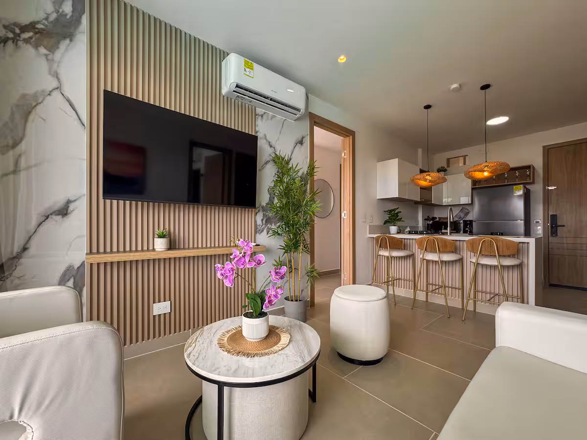 Sala con panel de mármol y listones que continúa hacia la barra de la cocina