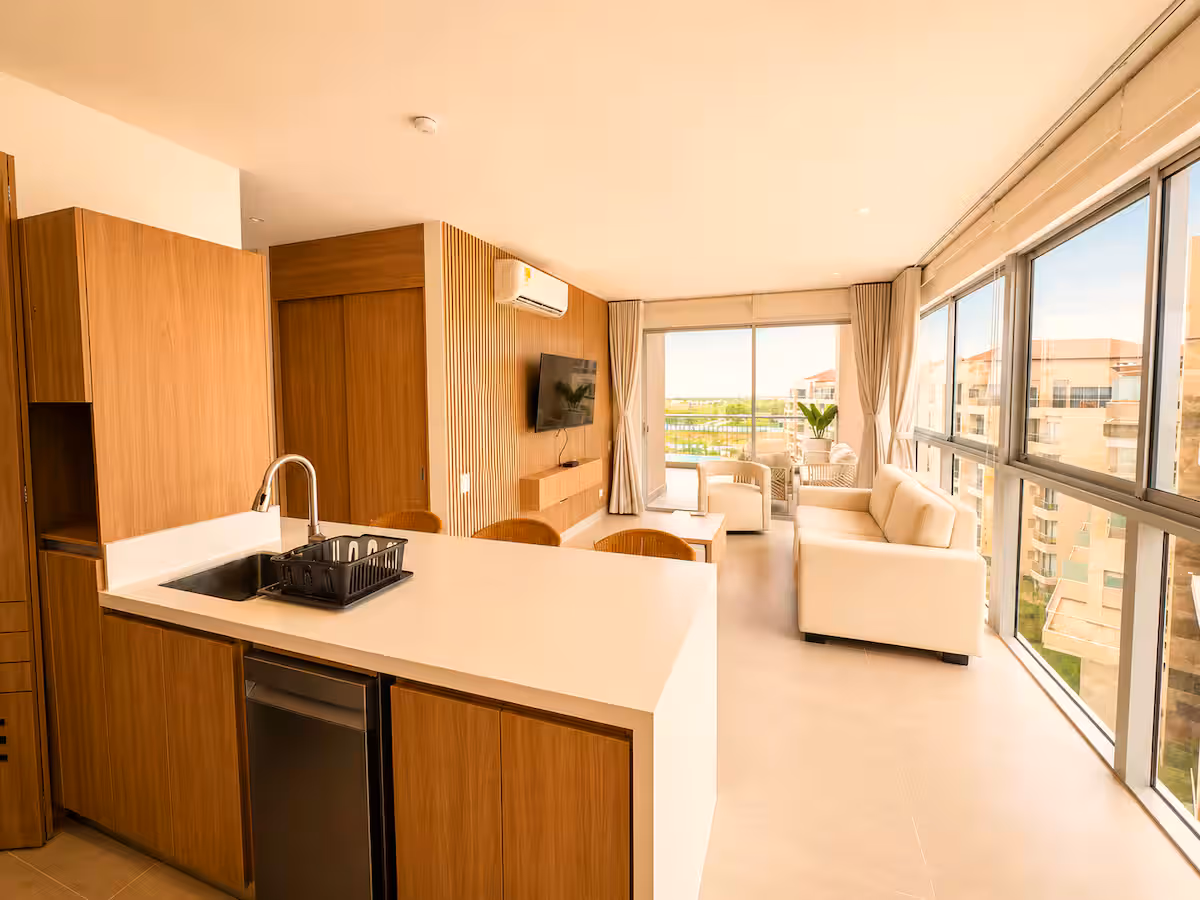Cocina abierta en madera, sala y ventanal esquinero