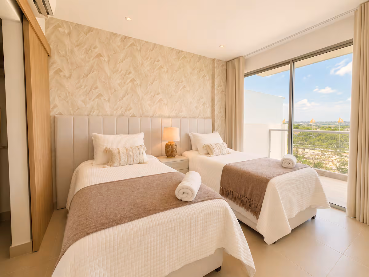 Dormitorio doble con papel tapiz, cabecero y vista al balcón