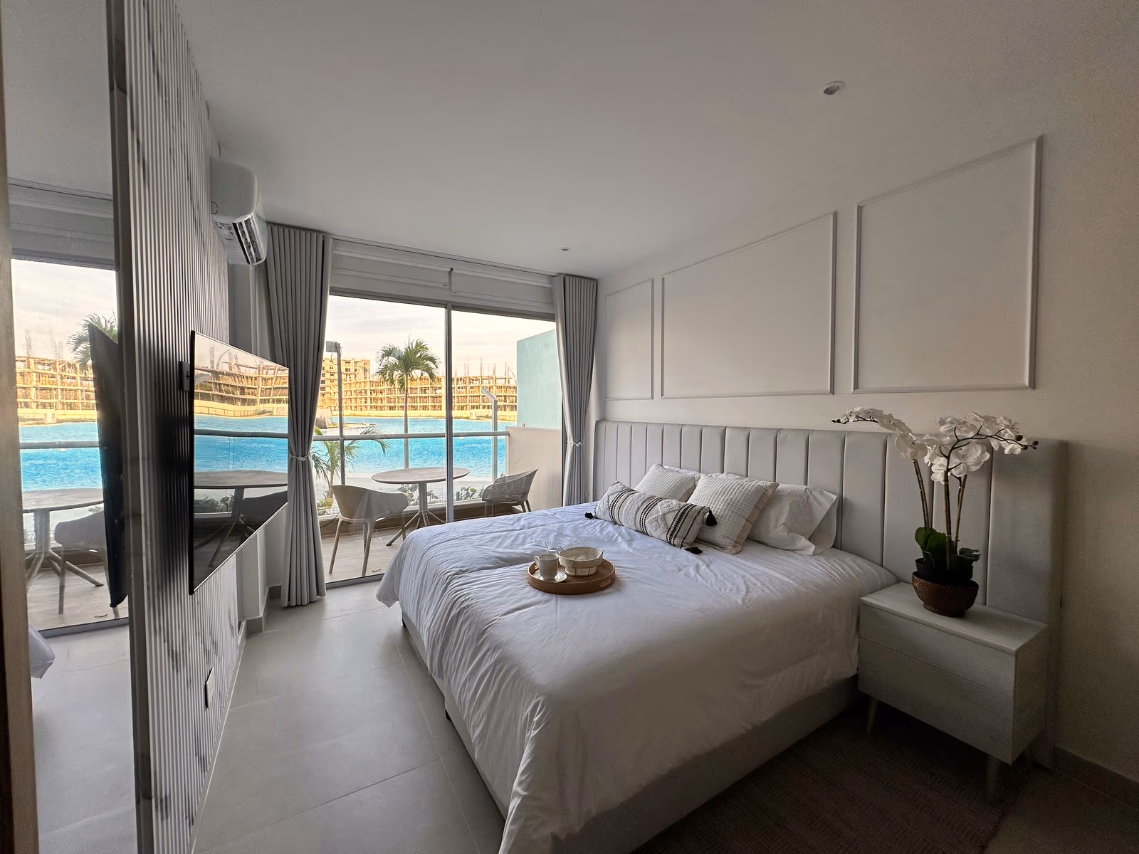 Habitación con molduras, panel de mármol para el TV y terraza con laguna