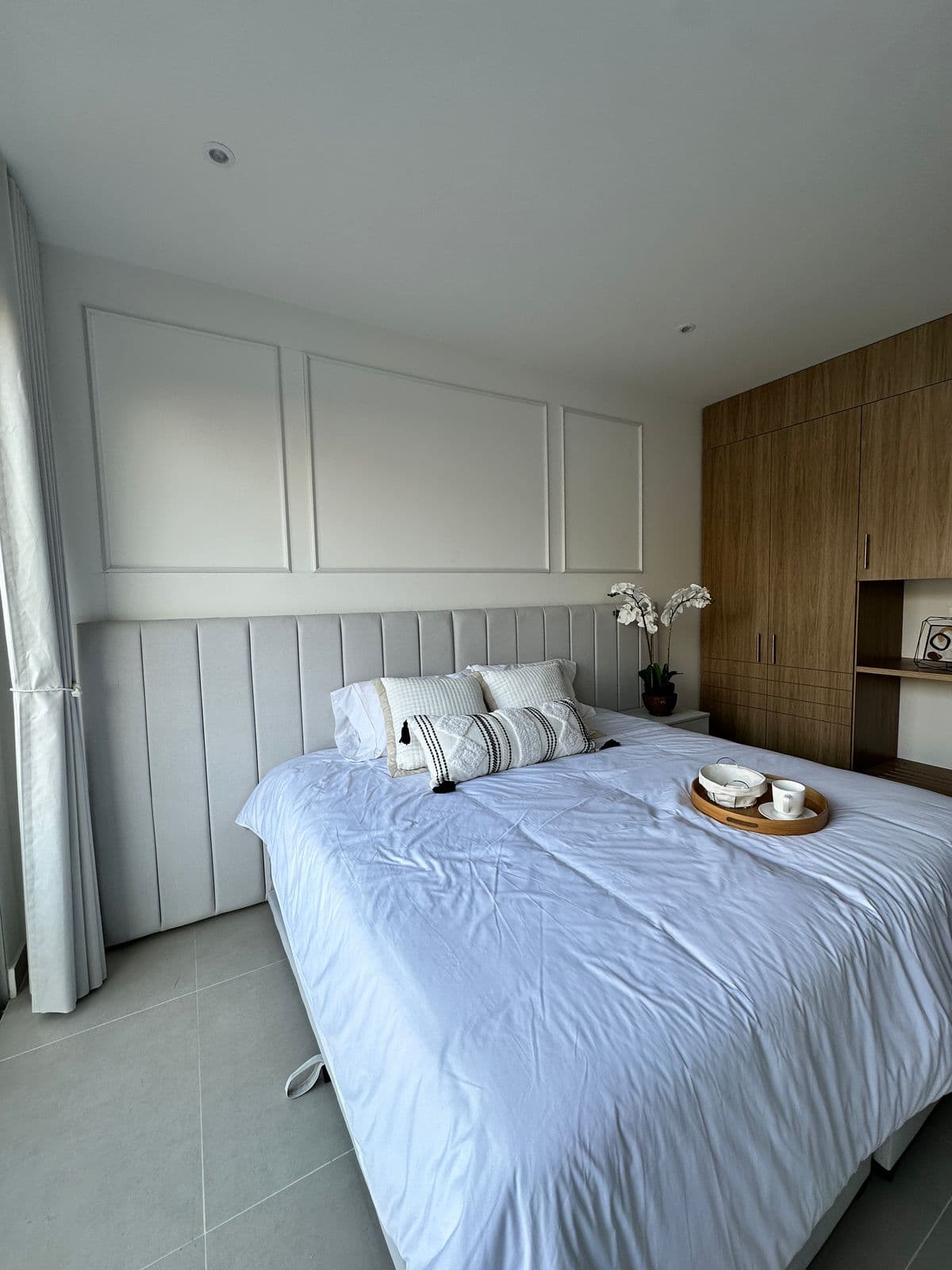 Habitación principal con cabecero tapizado en apartamento dotado por Reddy