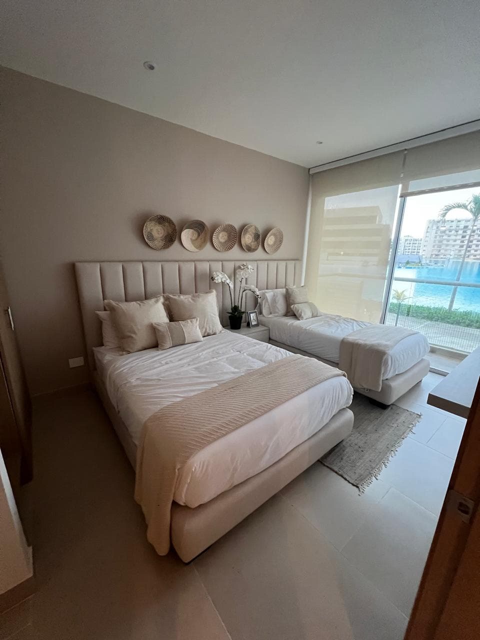 Habitación con cama doble y cama sencilla, vista a piscina