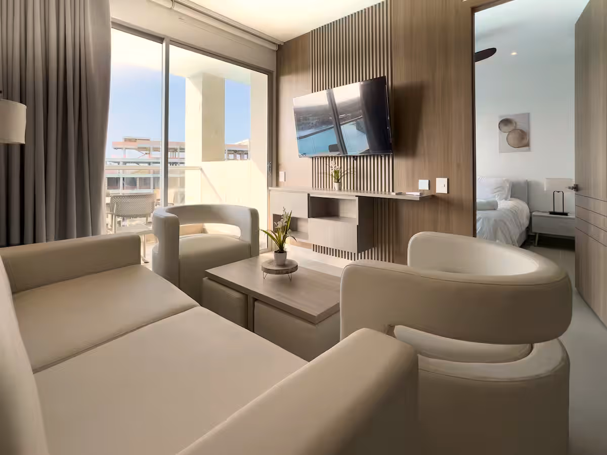 Sala con panel de listones, TV, cortinas, sofá y salida a terraza