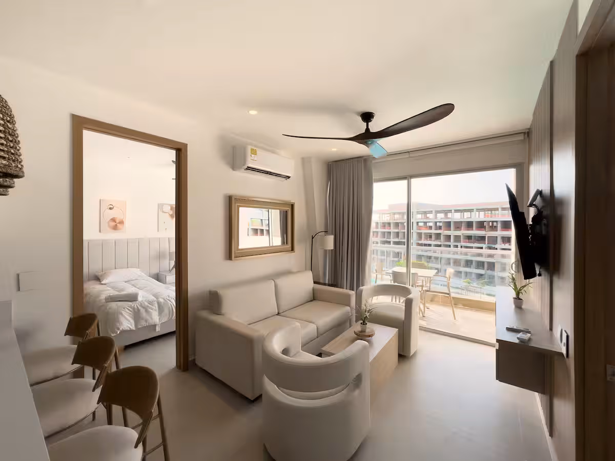 Sala con ventilador de techo, sofá, espejo grande y vista a la terraza