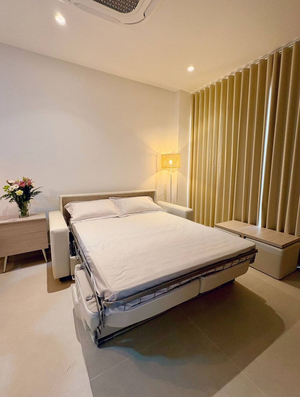 Sofá cama a medida abierto con cortinas verticales cream, fabricado e instalado por Reddy en Cartagena