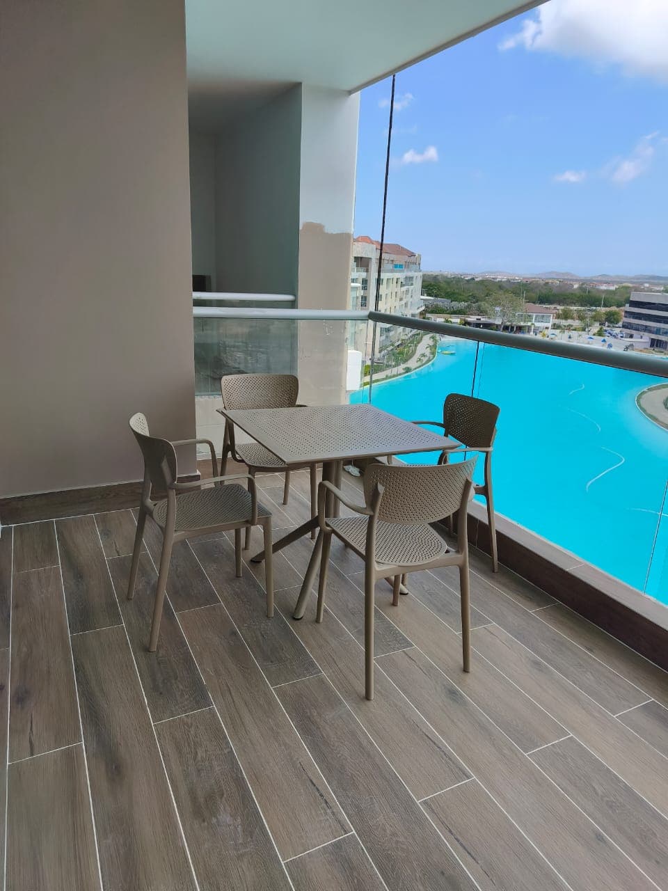 Mesa cuadrada y sillas Sky chair en terraza con vista a piscina, instaladas por Reddy en Cartagena