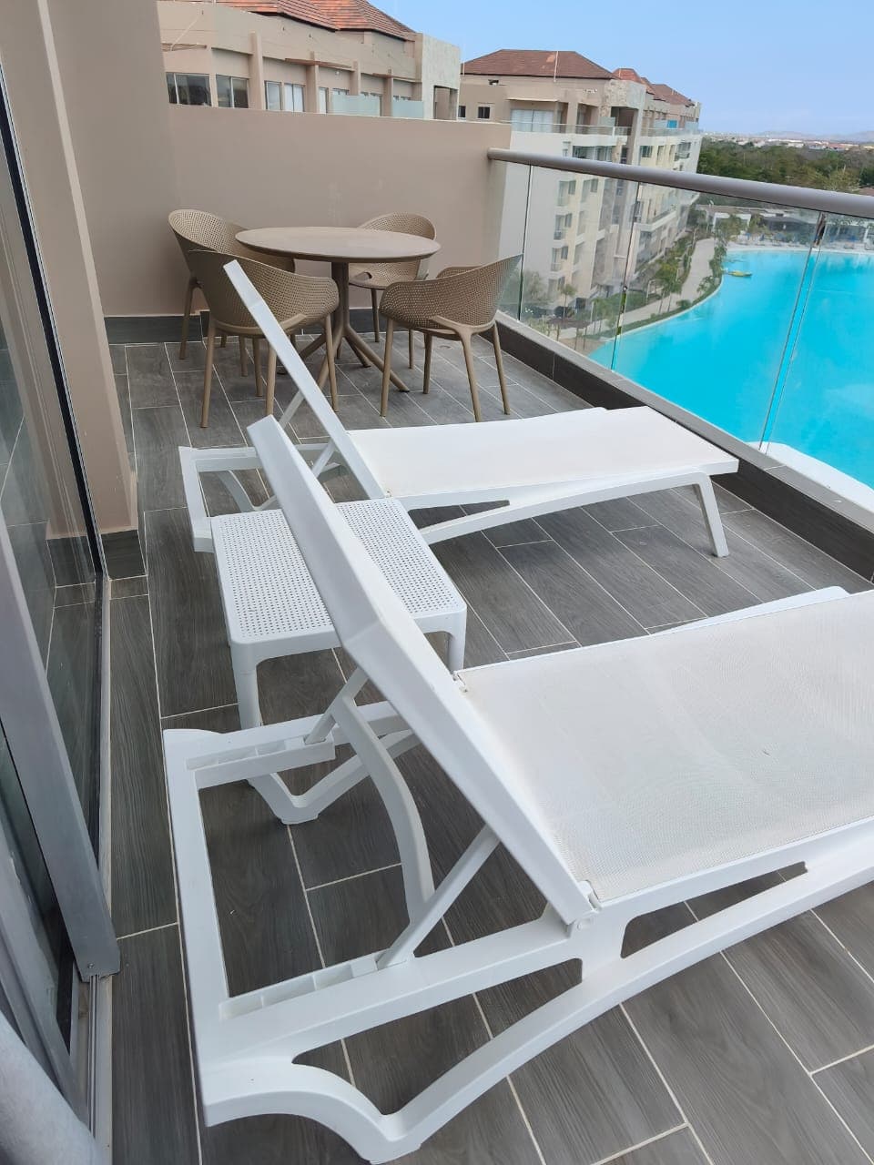 Lounges blancos reclinables con vista a piscina turquesa en Cartagena