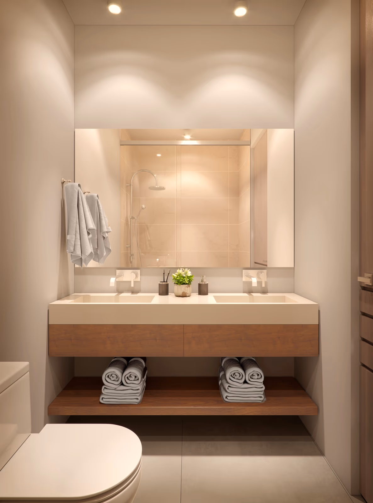 Baño con doble lavamanos, espejo iluminado y toallas enrolladas